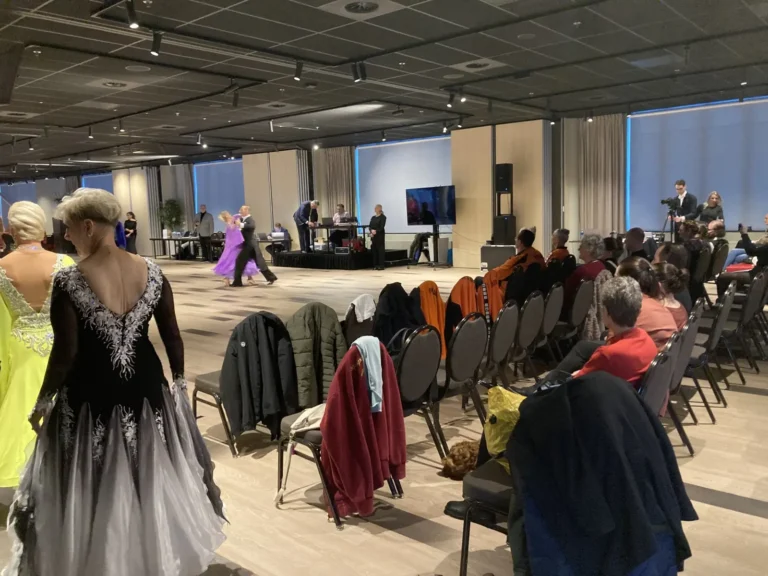 Danseres in zwarte jurk loopt langs het publiek naar de vloer